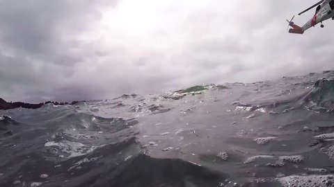 CIRCA 2018 - POV from the water of a Coast Guard helicopter search and rescue mission in open ocean.