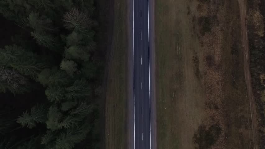 Aerial view of almost empty road it the forest. 2 lanes road.
