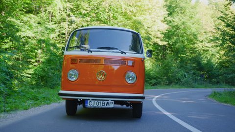 Driving an orange campervan on a road.
