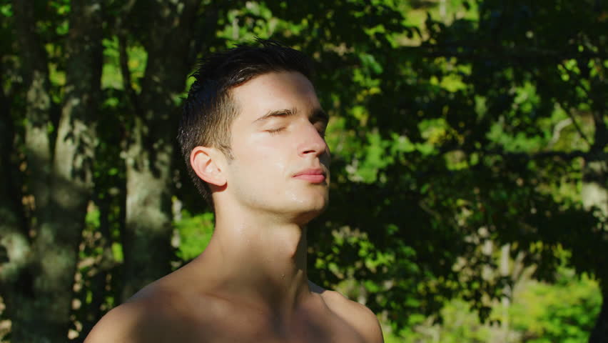 Close up view of a young man meditating outdoors. | Shutterstock HD Video #1022576506