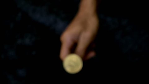 slowmotion shot tossing bitcoin to flip on heads or tails