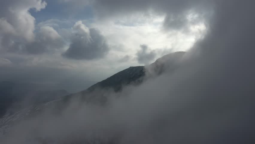 Heavy fog over the top of the mountain 4K drone footage