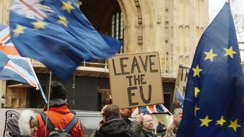 LONDON, circa 2019 - Slow motion shot of a group of Pro-EU remainers and Brexiteers demonstrating opposite Westminster Palace in London, England, UK
