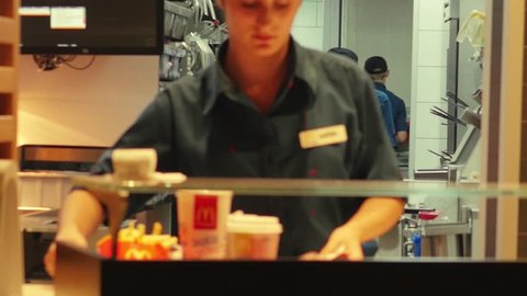 BATUMI, GEORGIA - October 2018: McDonald's worker serving customer. Slow motion dolly shot
