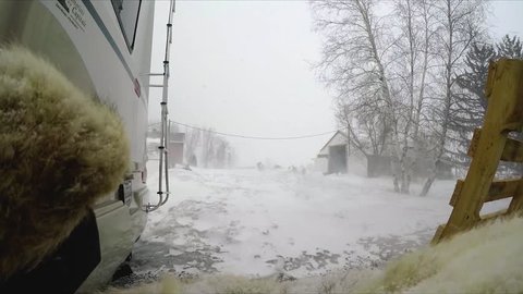 an old farm and a rv in a snowstorm