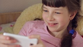 close-up portrait of a Caucasian teenage girl playing on a smartphone online game