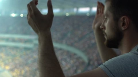Sport fan clapping hands, watching game at stadium, supporting favorite player