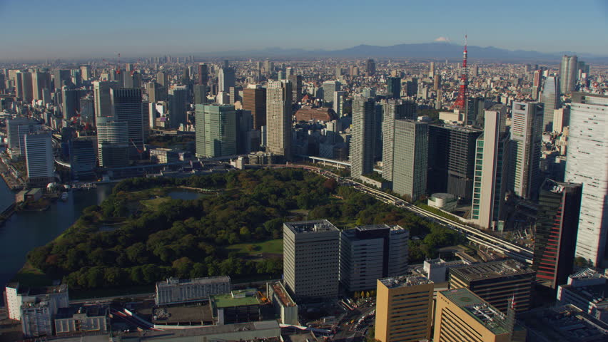 Tokyo, Japan circa-2018. Flying over Hamarikyu Gardens with Tokyo Tower and city buildings in distance. Shot from helicopter with RED camera.