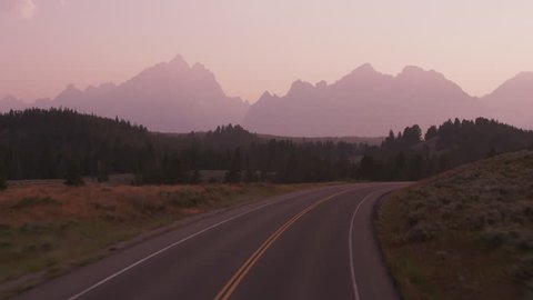 Driving along road in Grand Teton National Park at sunset
