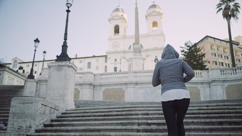 Active Italian woman running up the Spanish Steps passing a group of tourists to the top. Best fitness shot. Wide shot on 4k RED camera.