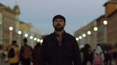 Fashionable Italian man walking in St. Peter's Square in the Vatican at Christmas, with soft sunset natural light. Medium shot on 4k RED camera on gimbal.