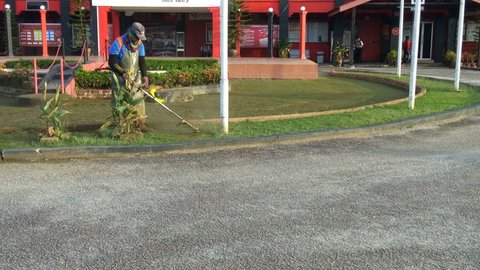 Perak, Malaysia, January 18 2019 - 
a man cut grass using a machine