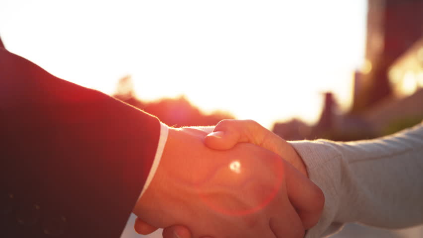 SLOW MOTION, DOF, LENS FLARE, CLOSE UP: Businessman and woman shake hands after a successful job interview. Unrecognizable work partners shake hands before saying goodbye at on a golden lit evening. | Shutterstock HD Video #1022645143