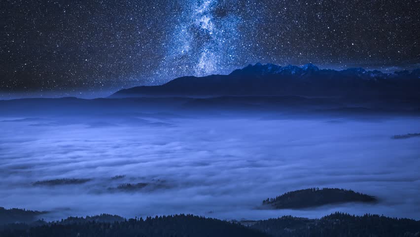 Milky way over flowing clouds in the Tatra Mountains at night, Poland, timelapse, 4K