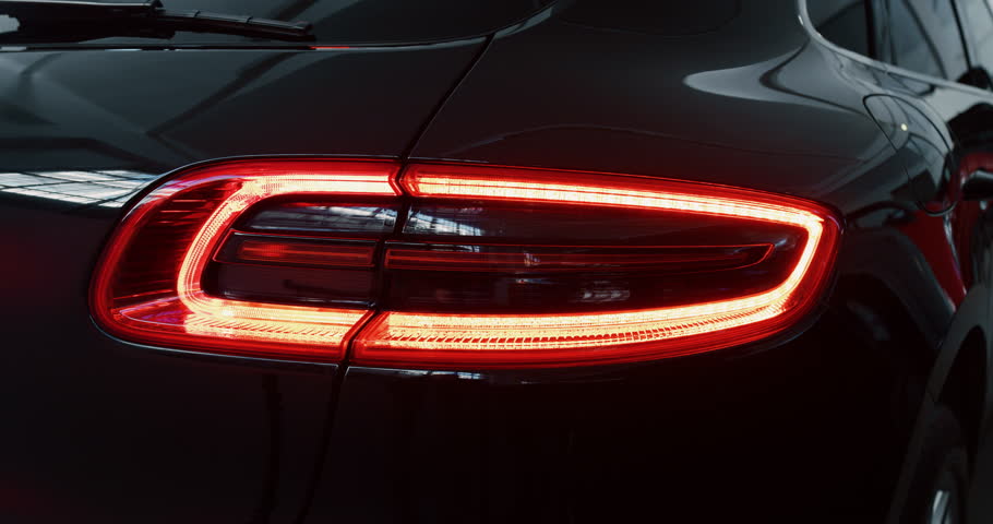 Close up of details of switched on tail lights of anonymous prestigious luxury modern car. Shot in 8K. Concept of passion for driving cars and engines, car dealerships, used cars,luxury cars,auto dial Royalty-Free Stock Footage #1022658691