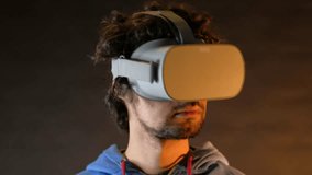 Close-up of young bearded man turning his head around in vr glasses