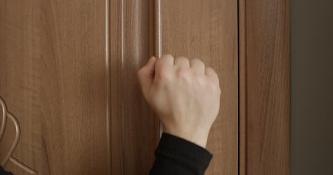 Knocking Door with Male and Female Hand Close Up Banging on the Wooden Brown Door