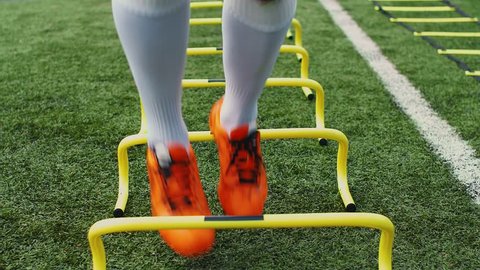 Soccer agility training equipment. Professional football player with training hurdles. 4k