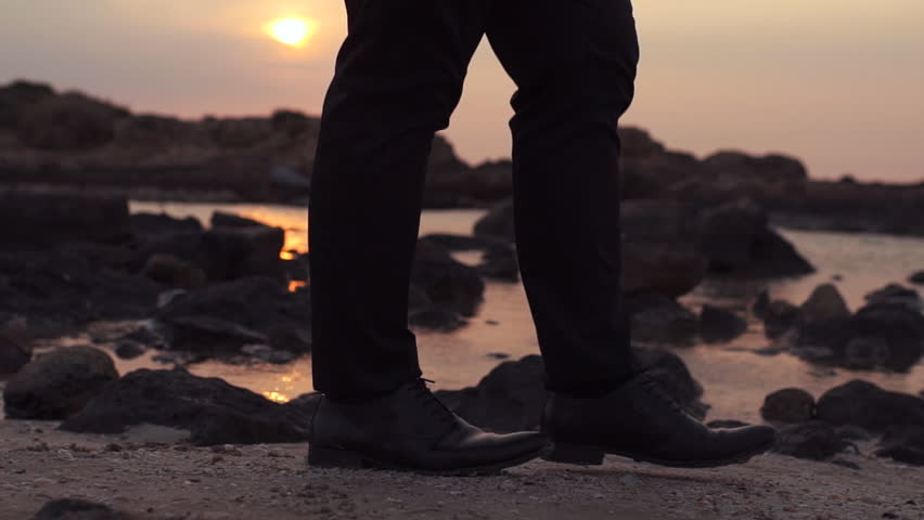 Businessman walking on a beach