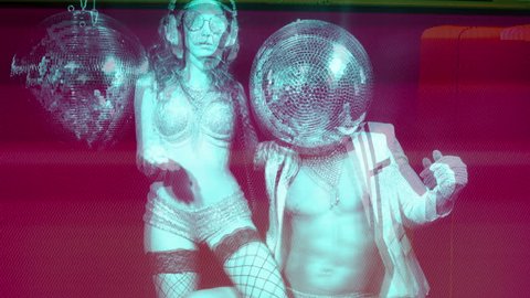 stunning disco woman in silver costume and her male partner with a mirror ball for a head