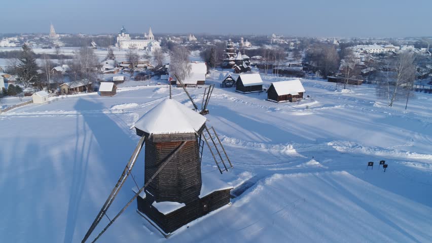 Panoramic view of the winter Suzdal with wooden windmill in the foreground
