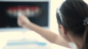 The dentist displays a picture of the patient's teeth on the monitor. Dental prosthetics - Powered by Shutterstock - Get 15% off with code: PIKWIZARD15