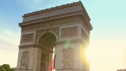 Hyperlapse at sunset around the Arc de Triomphe with tourists. Arch of triumph at the western end of the Champs Elysees and at the center of Place Charles de Gaulle