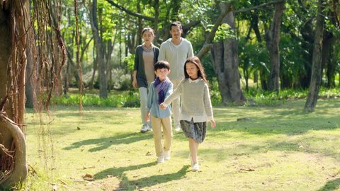 asian family with two children relaxing walking in park