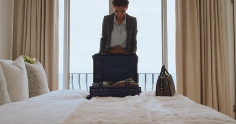 beautiful business woman packing suitcase in hotel room getting ready for road trip preparing luggage making travel plans
