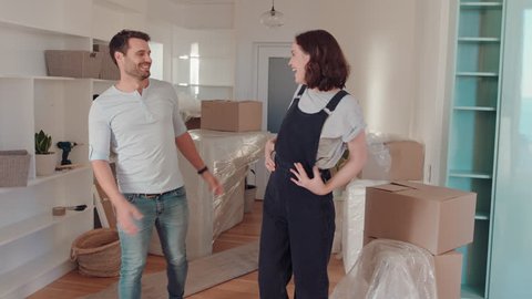 young couple moving house new home owners smiling enjoying successful move embracing in apartment