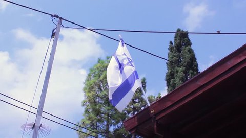 flag of israel hanging waving in the daylight
