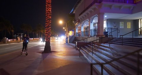 FORT LAUDERDALE, FL, USA - JANUARY 19, 2019: Fort Lauderdale Beach at night young people renting electric scooters