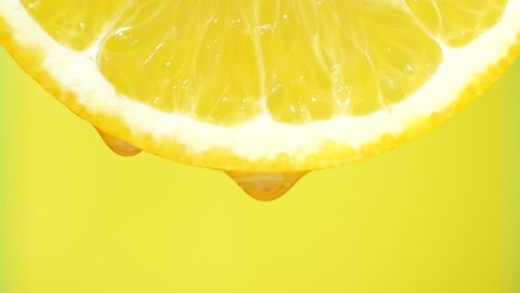 Water dropping on an orange slice , fruit for diet and healthy food. Yellow backgrond