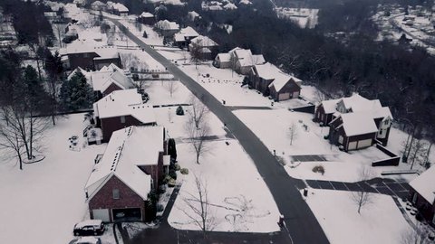 4K drone flight above peaceful, quiet neighborhood scene after the first snow fall of the year. Aerial top down views 