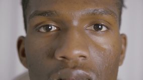 Extreme close-up of young African American man. Face of young guy looking at camera. Young man concept
