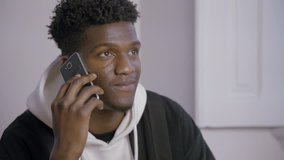 Portrait of smiling young man talking on mobile phone. African American male student calling up friend. Mobile communication concept
