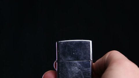 Zippo lighter being lit on a black background