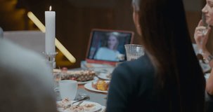 Family having a video call with relative during thanksgiving dinner, happy family greeting a remote guest. 4K UHD 60 FPS SLOW MOTION Blackmagic RAW