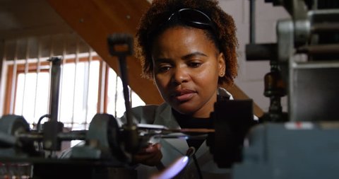 Close up of Female African-American worker measuring glass size in glass factory. Worker using caliper 4k