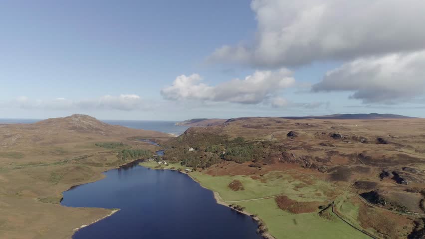 Cinematic tracking fly over of Loch Hope and surrounding valleys with large dramatic clouds in Scotland