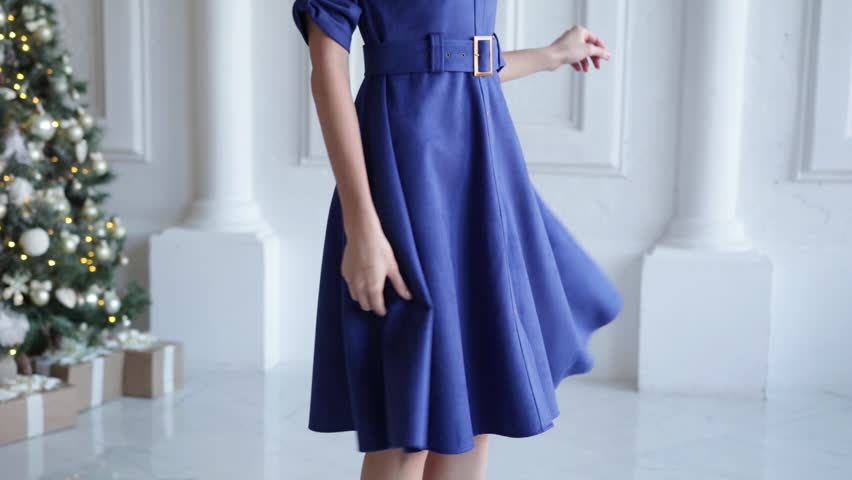 The girl in a long skirt is spinning. Close-up. A woman is spinning in a dress, view from below. A beautiful girl in a blue dress is spinning