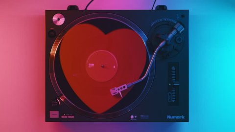 Varna, Bulgaria January 2019 turntable Numark: red heart Vinyl Retro Record white table with plates. Stylus with needle. Red blue light. Loop. Valentine's Day. Popular Disco Trends 70s, 80s, 90s