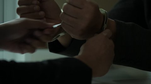 Criminal businessman giving bribe and releasing prison, taking handcuffs off.