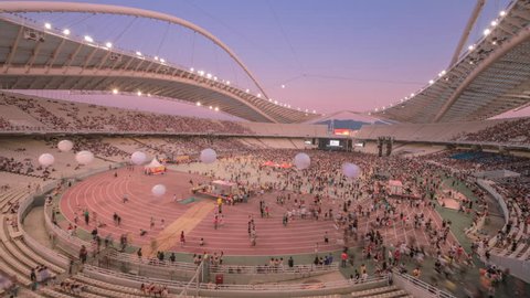 4K Wide angle aerial day to night time lapse shot in July 2011 in Athens Greece, at the Olympics sports stadium, as huge crowds of people gather to the arena to watch a live rock music concert.