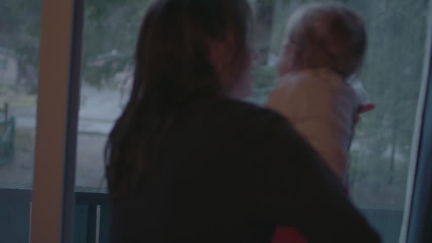 Close up of mom and baby toddler looking out of the windows in the mountains