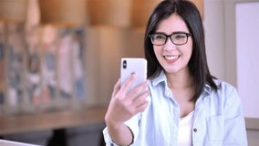 Beautiful Asian girl happy video chatting or having a facetime conversation on smartphone. Lifestyle and technology concept. Slow Motion