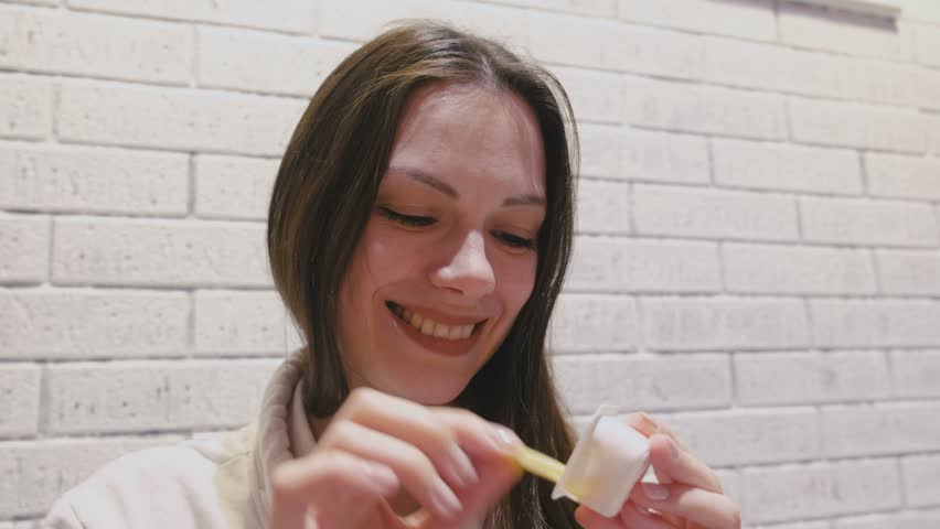 Woman eating French fries with cheese sauce in cafe.