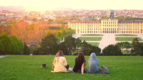 VIENNA, AUSTRIA - CIRCA APRIL 2018: Panorama view on the Schoenbrunn Palace as tourist pass by on the walkway of the castle park circa April 2018 in Vienna, Austria.
