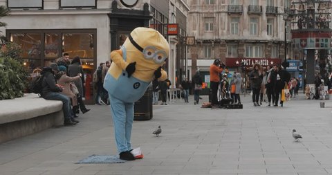 LONDON ENGLAND JANUARY 2019: Street performer dancer singer minion costume silly funny weird circus clown square
