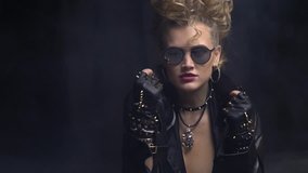 Beautiful rocker girl in sunglasses adjusting the collar on her leather jacket, slight slow motion - Powered by Shutterstock - Get 15% off with code: PIKWIZARD15
